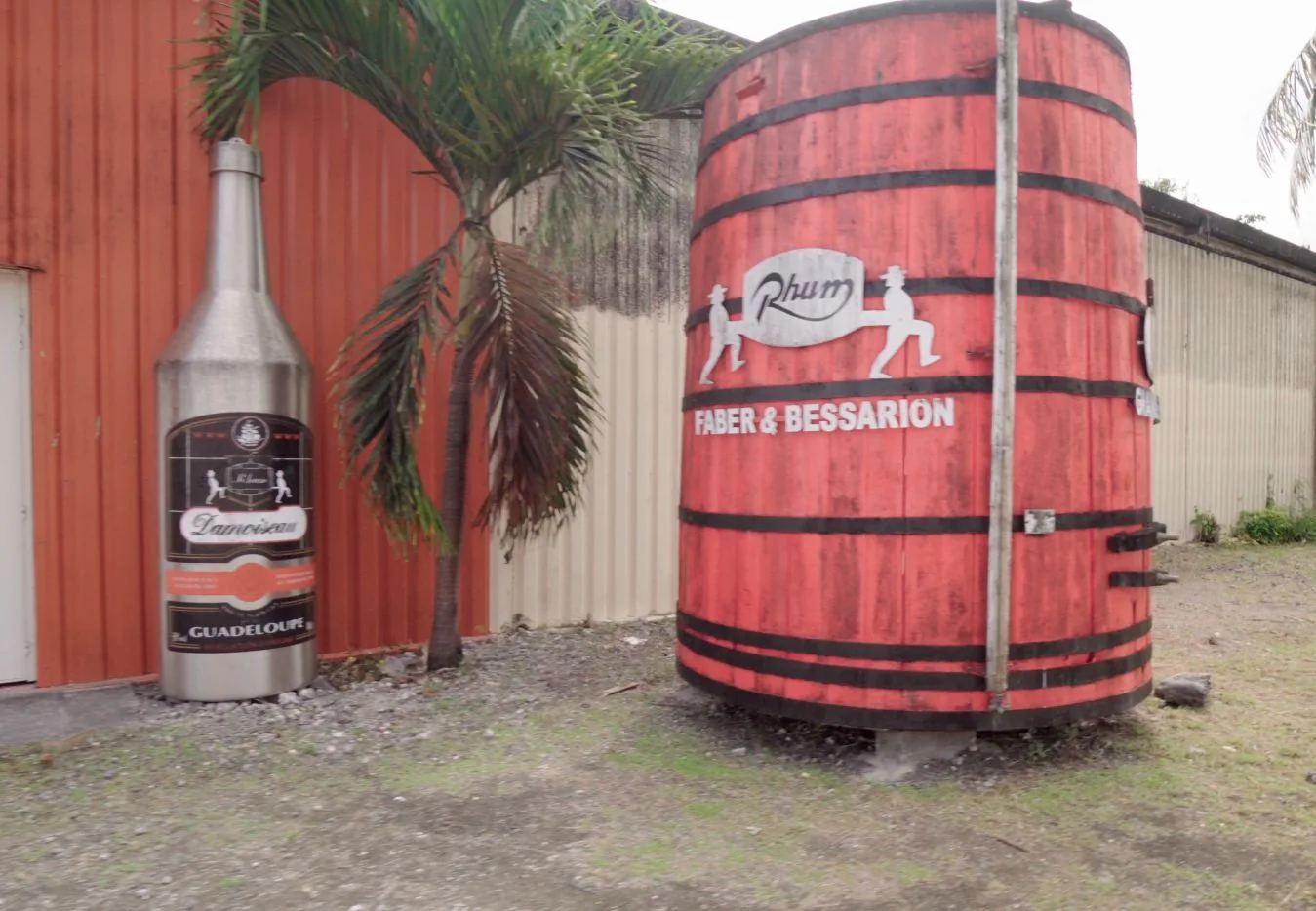 Grand foudre rouge exposé à l’extérieur de la distillerie Damoiseau au Moule