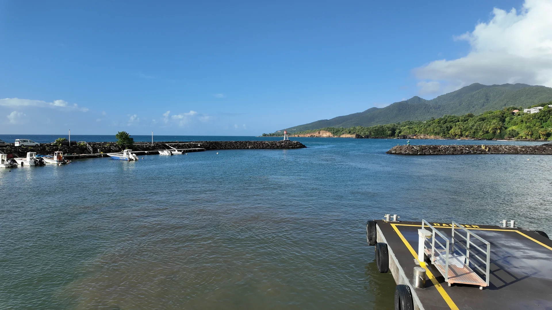 Vue sur un quai, des bateaux et les digues d'un port durant un trajet maritime dans l'archipel des Saintes